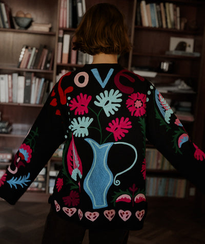 Maggie Suzani Love Jacket mt 'Love' op de achterkant bestaat uit een katoenen canvas met opvallende Suzani borduurwerk. Het jasje heeft zakken aan de voorkant en knopen middenvoor. Je ziet de Indiaanse inspiratie aanwezig in de borduur ontwerpen waarbij traditionele Indiase motieven zijn gemengd met universele en eigentijdse symbolen als harten, liefde en klaproosbloemen.